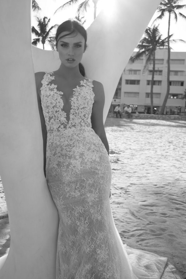 Netta BenShabu Isadora Wedding Dress - Fit & flare plunging V neck gown with floral appliques over lace, an illusion bodice and open back.