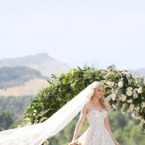Martina Liana 1048 Wedding Dress Sample Sale - A Line with 3D flowers and layers of tulle, a sweetheart neckline and fitted sheer bodice with draped waist.