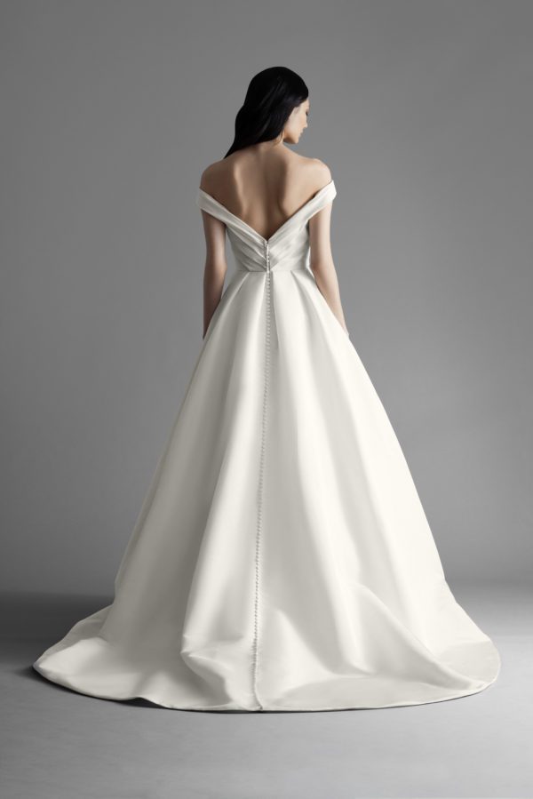 Allison Webb Ava Wedding Dress - Ivory silk faille pleated full A-line bridal gown with pockets and draped off the shoulder bodice, chapel train.