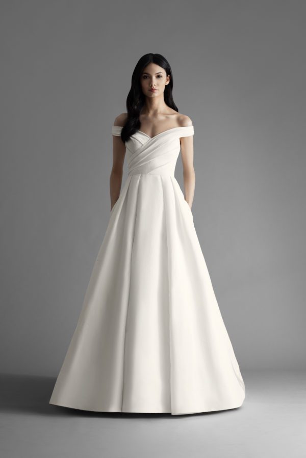 Allison Webb Ava Wedding Dress - Ivory silk faille pleated full A-line bridal gown with pockets and draped off the shoulder bodice, chapel train.