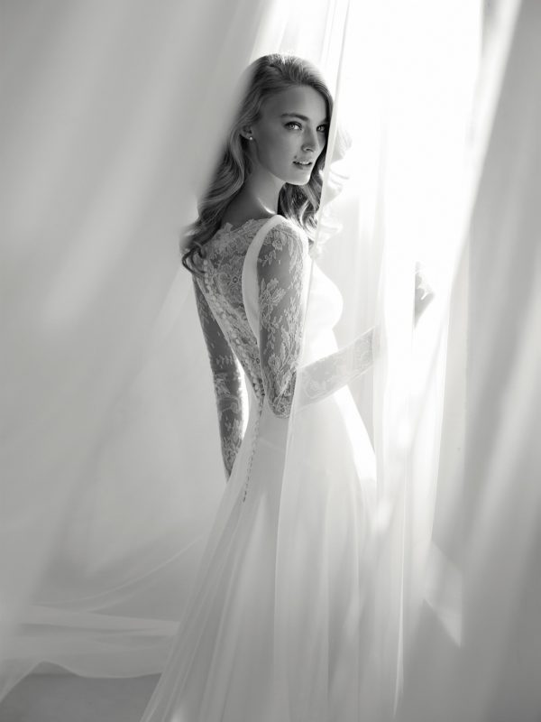 Pronovias Atelier Ribel Wedding Dress - Modified A Line style dress with illusion tattoo style long sleeves, crepe and lace bateau neckline and low open back.
