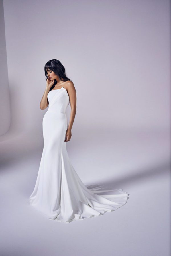 Suzanne Neville Aurelia Wedding Dress - Fitted bodice with hidden corsetry and a contemporary straight strapless neckline with folded fan detail on one side, Italian crepe fabric and a fit to flare skirt. 