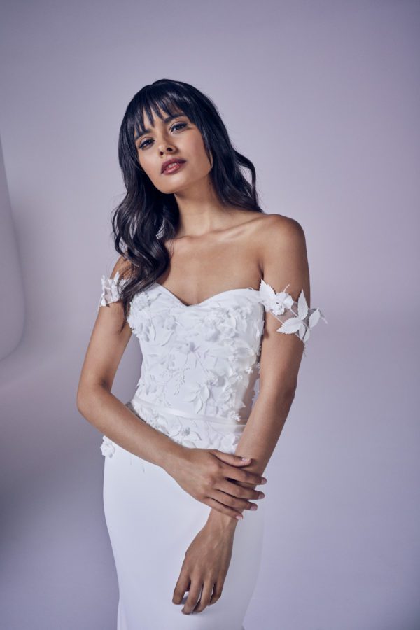 Suzanne Neville Romance Wedding Dress - Crepe dress with sweetheart neckline, 3-D Flower appliqués, off the shoulder straps and a fit and flare skirt.