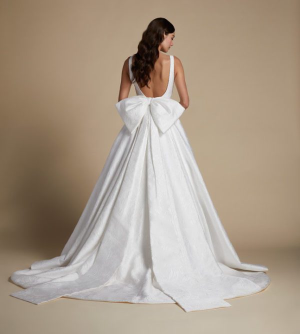 Allison Webb Wellsley Wedding Dress - a floral jacquard A-line gown with pleats, a plunging V-neck, low scoop back, pearl detail and a detachable bow.