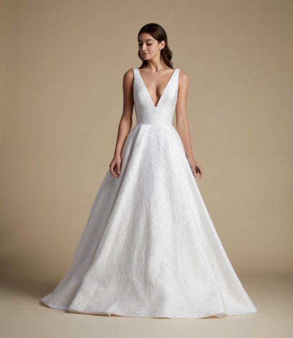 Allison Webb Wellsley Wedding Dress - a floral jacquard A-line gown with pleats, a plunging V-neck, low scoop back, pearl detail and a detachable bow.
