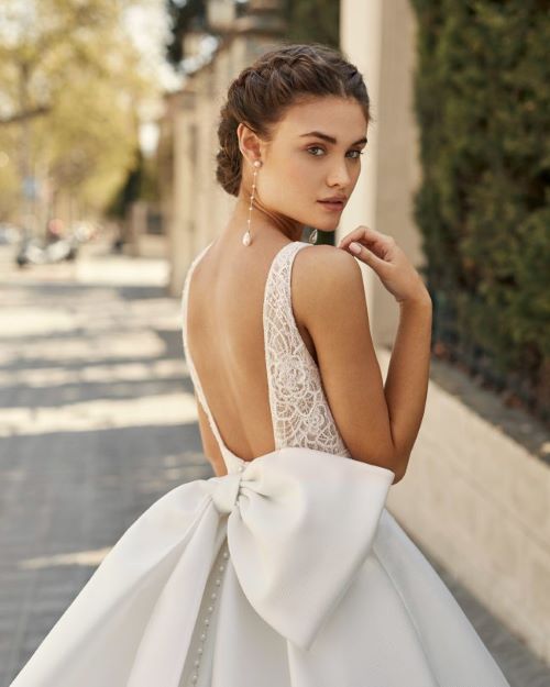 Rosa Clara Aire Alma Wedding dress is a Ballgown with beaded lace bodice, deep-plunge neckline and illusion back with asymmetrical bow.