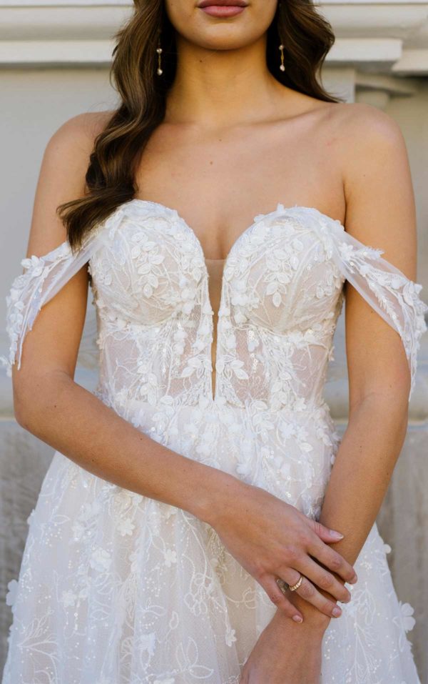 artina Liana 1321 Wedding Dress — A-line wedding dress with 3d floral appliqués, sweetheart neckline, off-the-shoulder straps, and front slit details.