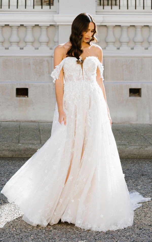 artina Liana 1321 Wedding Dress — A-line wedding dress with 3d floral appliqués, sweetheart neckline, off-the-shoulder straps, and front slit details.