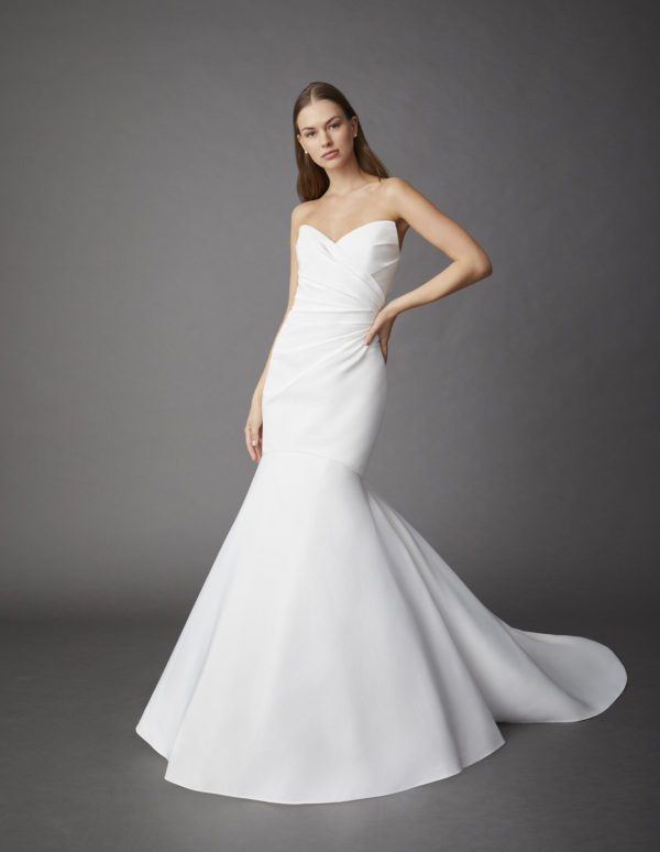 Allison Webb Carson Wedding Dress - Fit and flare Pearl blended gown, including a peaked neckline, draped body, and clean skirt without a pick up.