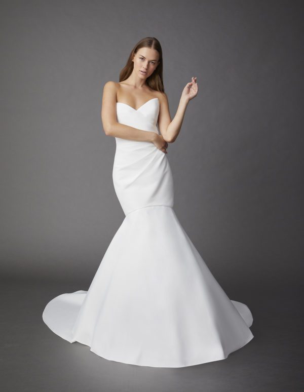Allison Webb Carson Wedding Dress - Fit and flare Pearl blended gown, including a peaked neckline, draped body, and clean skirt without a pick up.