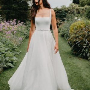 Suzanne Neville Hailey Wedding Dress - A Line featuring a square neckline in crepe, eloquent belt detail and organza skirt.