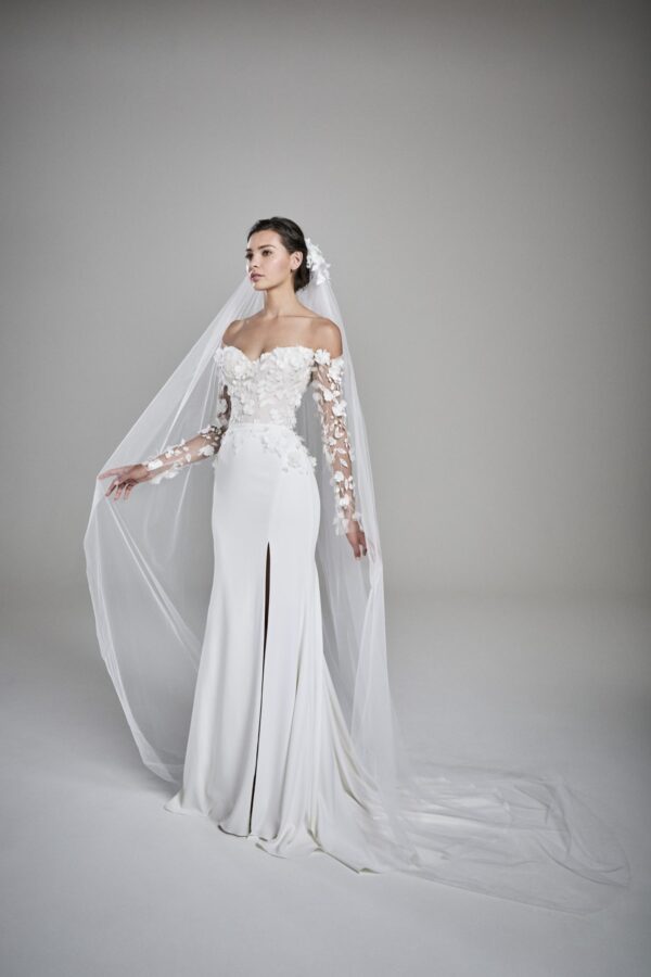 Suzanne Neville Eden Wedding Dress - Elegant sheath dress with long sleeves, sweetheart neckline, featuring 3-D floral appliqué with center slit.
