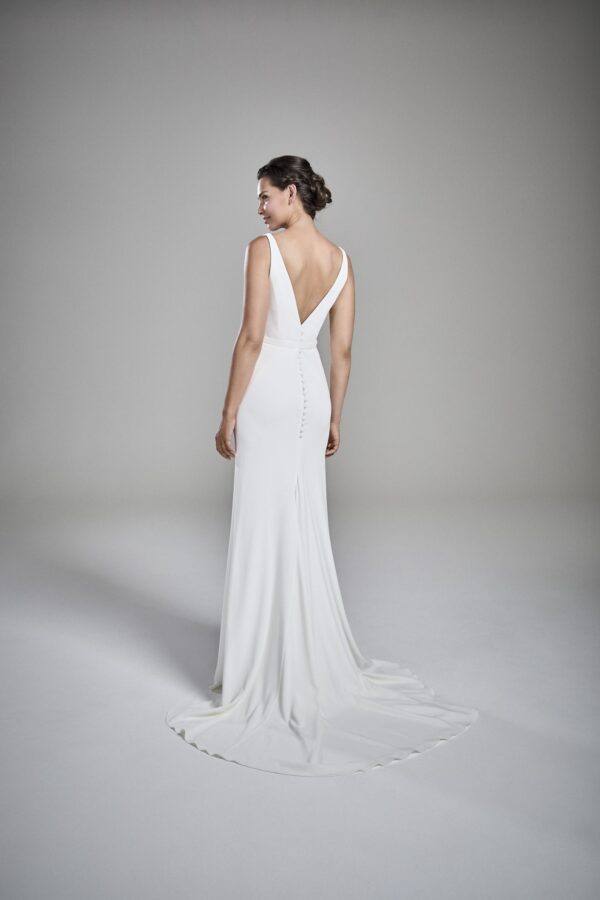 Suzanne Neville Kaia Wedding Dress - Fit and flare dress with a deep V-neckline and V- back, with open slit on front, belt detail and small train