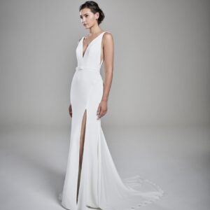 Suzanne Neville Kaia Wedding Dress - Fit and flare dress with a deep V-neckline and V- back, with open slit on front, belt detail and small train