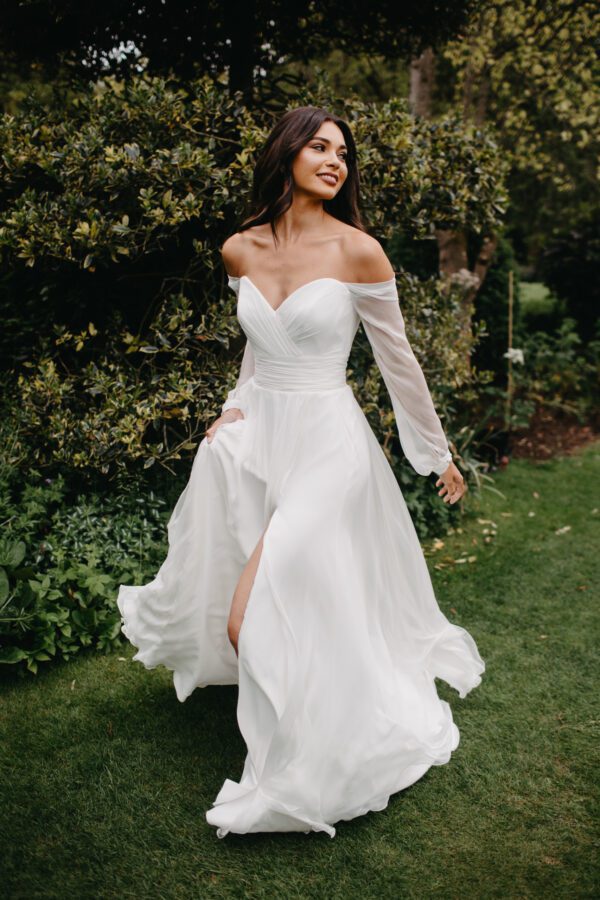 Suzanne Neville Molly Wedding Dress - Gorgeous A-line gown with a front slit, sweetheart neckline and off the shoulder long sleeves.