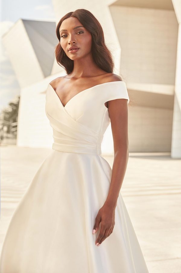 Paloma Blanca 4977 Wedding Dress - A line silhouette with draped Mikado fabric, off the shoulder bodice, covered buttons, full circle skirt with pockets.