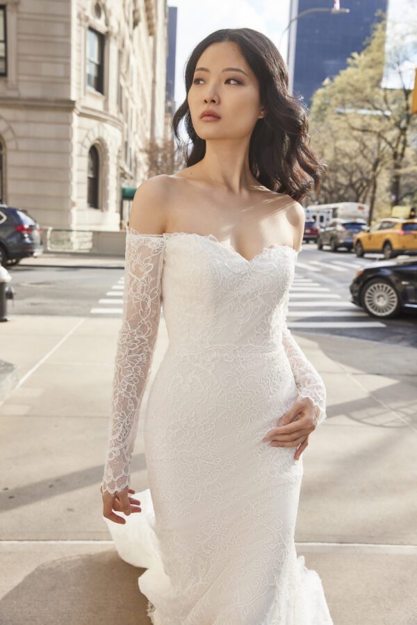 Allison Webb Tory Wedding Dress - Corded lace fit and flare gown with off the shoulder sheer long sleeves, illusion back and buttons to the end of train.
