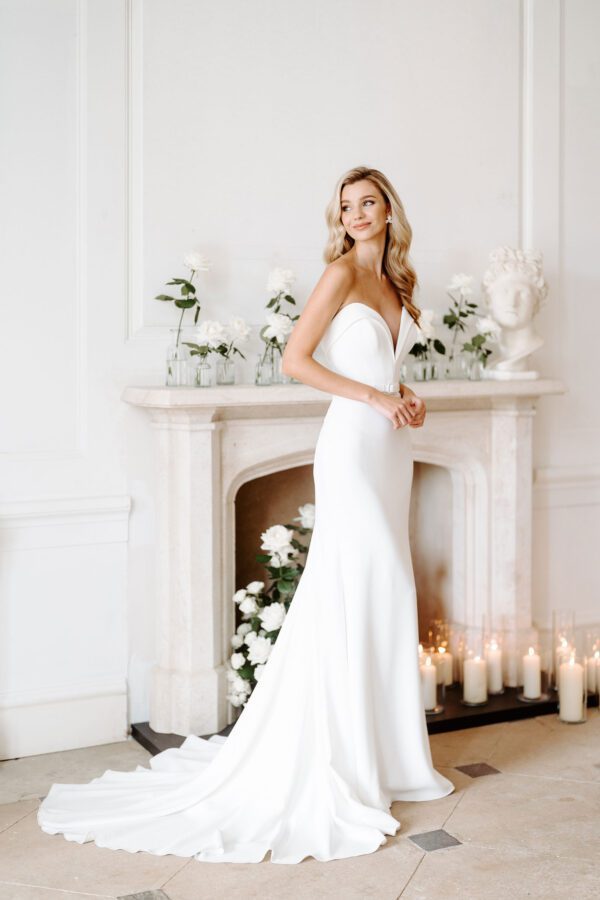 Suzanne Neville Corinthia Wedding Dress - Corinthia features a structured sweetheart neckline with deep v cleavage, a thin belt detail which sits above a fit-to-flare skirt.
