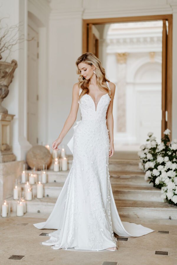 Suzanne Neville Pellicano Wedding Dress - Fitted gown with a plunge neckline, button fastening, adorned with floral 3d appliqués from top to bottom.