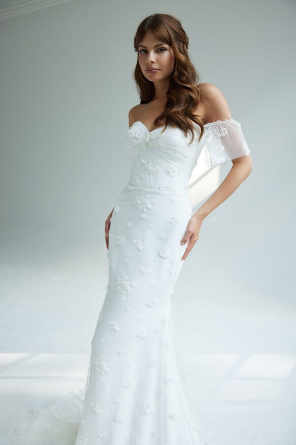 Suzanne Neville Tierra Wedding Dress - Fit and flare dress with sweetheart neckline, detachable off the shoulder sleeves, 3D Appliqués, and small train.