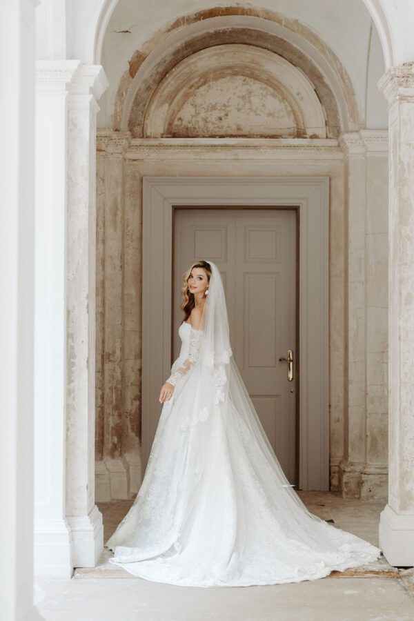Suzanne Neville Wellesley Wedding Dress - Modifies A Line dress with a sweetheart neckline, illusion lace off the shoulder detachable sleeves, open slit on front and fitted corset bodice. 