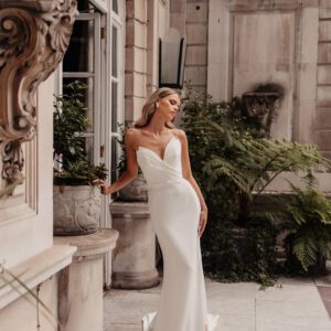 Suzanne Neville Mozart Wedding Dress - Fit and flare style dress with a deep plunging strapless v-neckline, draped detail on bodice and belt detail.