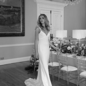 Suzanne Neville Zimmer Wedding Dress - Fit and flare dress with a structured draped bodice, straps, low open back with criss cross end and train.