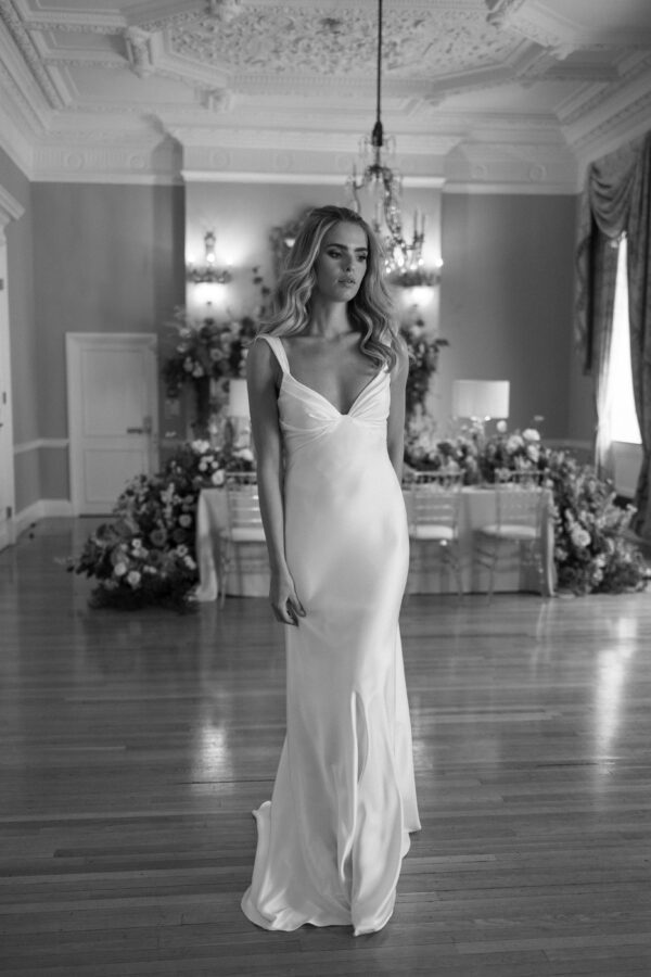 Suzanne Neville Zimmer Wedding Dress - Fit and flare dress with a structured draped bodice, straps, low open back with criss cross end and train.