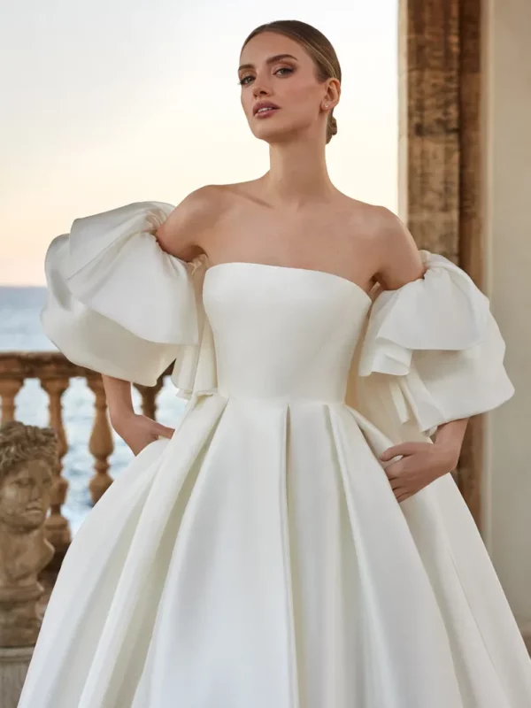 Pronovias Harmonia Wedding Dress - Ballgown with perfect folds of drapery on a classical Greek, detachable ruffle sleeves and cape.