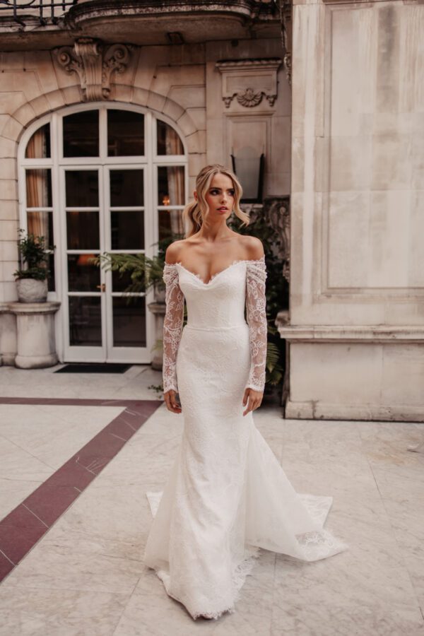 Suzanne Neville Stravinsky Wedding Dress - Elegant corseted, off-the-shoulder bodice with beautiful long lace sleeves and a fitted lace skirt.
