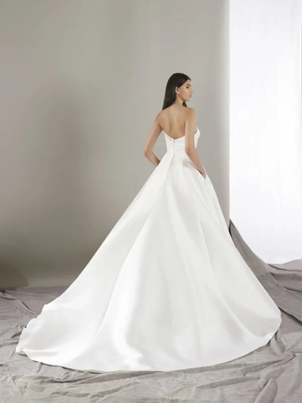 Pronovias Keoni Wedding Dress - Princess-cut with flattering pleats, Mikado fabric, sweetheart neckline, pockets details, wide train and open back.