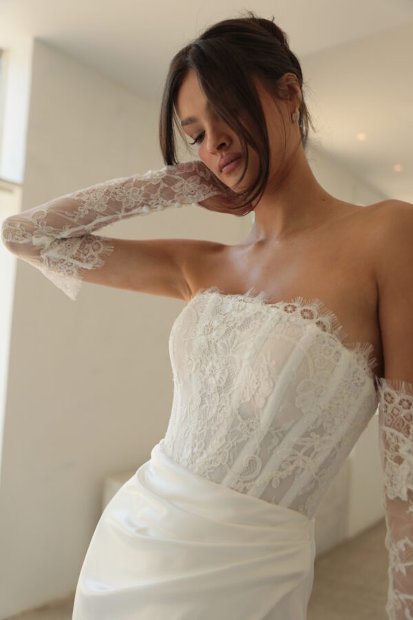 Mariana Hardwick Harper Wedding Dress - A-Line style dress with straight neckline, corset bodice, lace, ruched skirt on waist and side slit. 