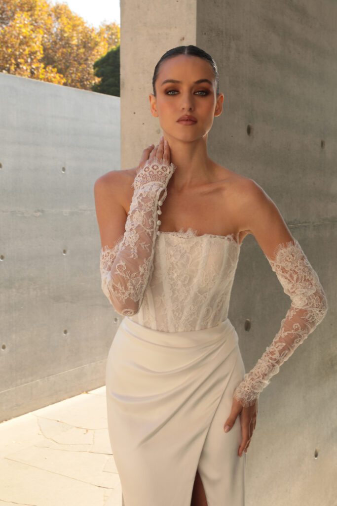 Mariana Hardwick Harper Wedding Dress - A-Line style dress with straight neckline, corset bodice, lace, ruched skirt on waist and side slit. 