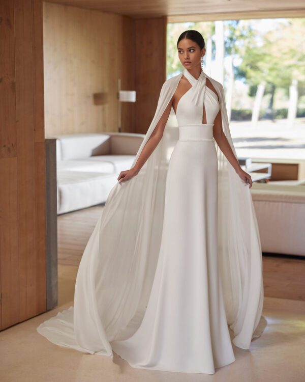 Rosa Clará Abira Wedding Dress - Simple two-piece sheath-style wedding dress, with beadwork details. Featuring a halter neckline and open back with a georgette cape. An on-trend Rosa Clará set.