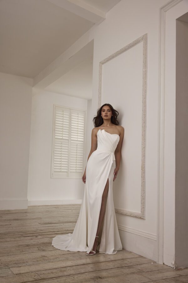 Suzanne Neville Buttercup Wedding Dress - A-line skirt with a side slit, strapless, corseted bodice, sweetheart neckline and asymmetrical detail.