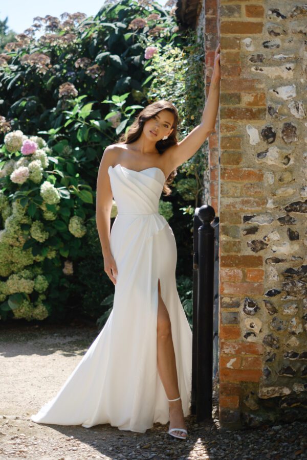 Suzanne Neville Buttercup Wedding Dress - A-line skirt with a side slit, strapless, corseted bodice, sweetheart neckline and asymmetrical detail.