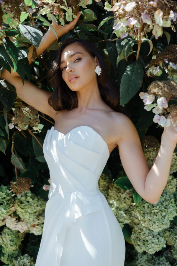 Suzanne Neville Buttercup Wedding Dress - A-line skirt with a side slit, strapless, corseted bodice, sweetheart neckline and asymmetrical detail.