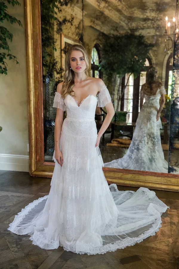 Estee Couture Francine Wedding Dress - A-Line style dress in strapless chantilly lace with tiered skirt, bustier with detachable sleeves, light weight construction, chapel train.