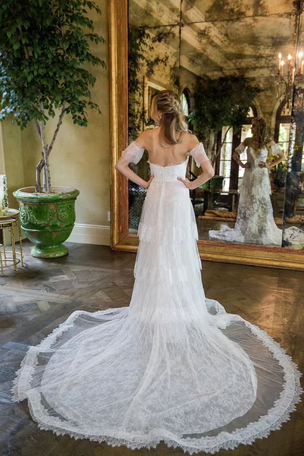 Estee Couture Francine Wedding Dress - A-Line style dress in strapless chantilly lace with tiered skirt, bustier with detachable sleeves, light weight construction, chapel train.