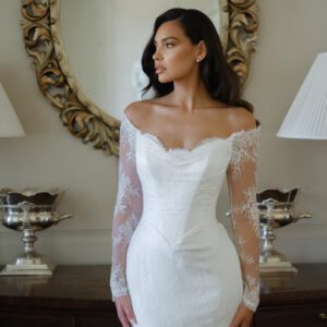 Suzanne Neville Camomile Wedding Dress - Fit and Flare style dress with beautiful bateau neckline, all over lace, off the shoulder long sleeves, V cut on waist, V-back and covered buttons. 