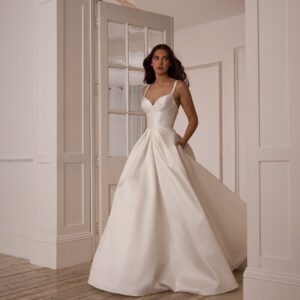 Suzanne Neville Mistletoe Wedding Dress - A-Line style dress with corset style bodice, skirt details, sweetheart neckline, side pockets, spaghetti straps, low back and covered buttons. 