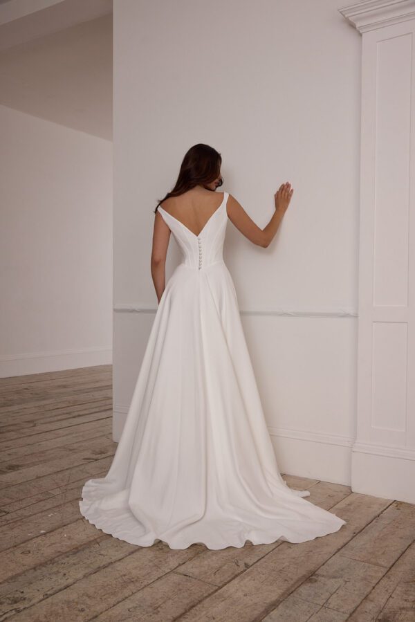 Suzanne Neville Fittonia Wedding Dress - A-Line style dress with low v waist, fitted corset bodice, bateau neckline, low v-back and covered buttons.