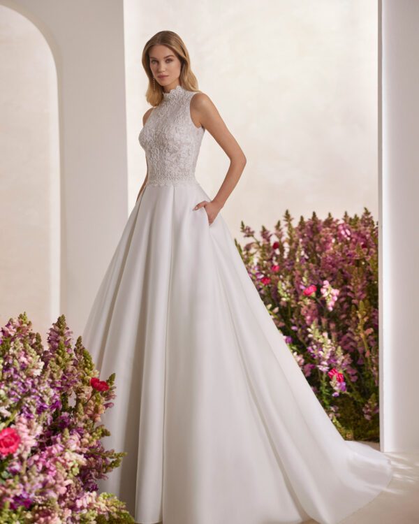 Rosa Clará Tibor Wedding Dress - Classic princess wedding dress made with French jewelled lace and Lira mikado. Showcase a halter neckline, keyhole back and skirt with pockets.