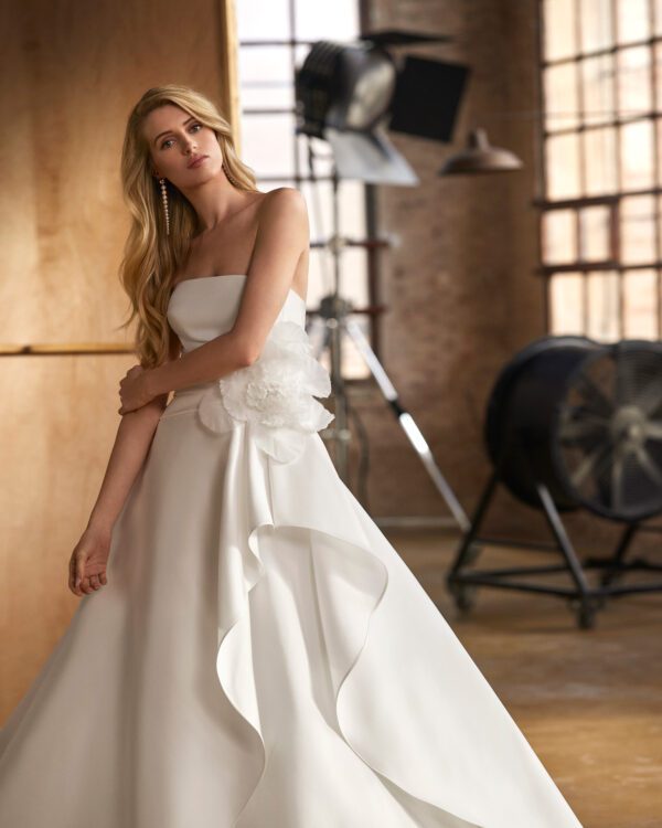 Rosa Clará Walezia Wedding Dress - Classic long two-piece ballgown-style wedding dress, made in magnolia mikado and rebrodé lace. Featuring a strapless neckline, plain, voluminous skirt, and jacket in rebrodé lace.