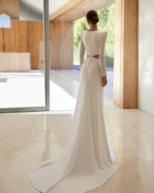 Modern sheath-style wedding dress, crafted in stretch crêpe. Featuring a square neckline, closed back, long sleeves and a cut-out embellishment.