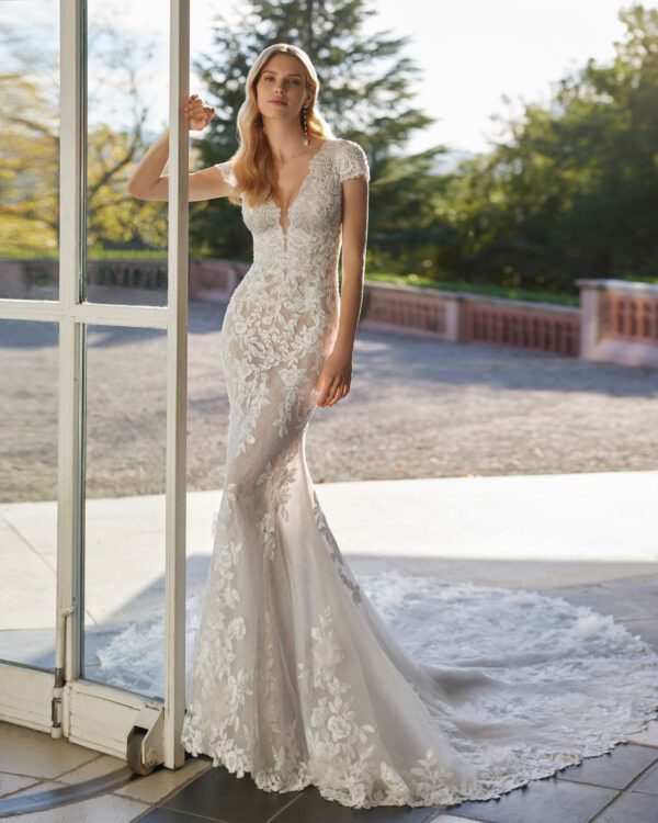 Rosa Clará Velmat Wedding Dress - Fantasy style long mermaid-style wedding dress crafted in lace with beadwork details. Featuring a V-neckline, buttoned back and short sleeve.