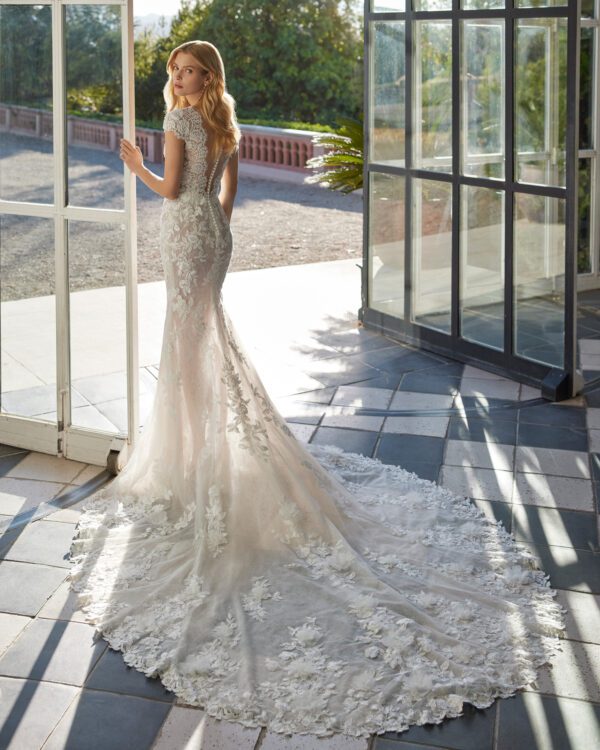 Rosa Clará Velmat Wedding Dress - Fantasy style long mermaid-style wedding dress crafted in lace with beadwork details. Featuring a V-neckline, buttoned back and short sleeve.