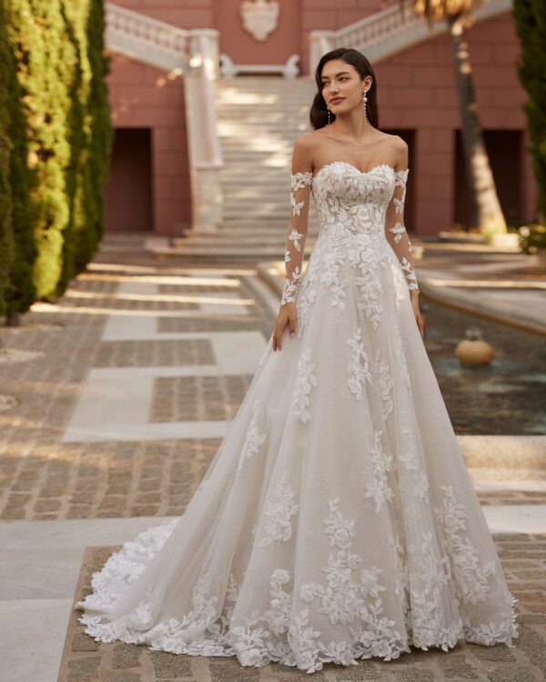 Rosa Clará Iza Wedding Dress - Long romantic princess wedding dress, crafted in lace with a snow tulle skirt. Featuring a sweetheart neckline, buttoned back, detachable sleeves and detachable off-shoulder cuff neckline.