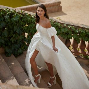 Rosa Clara Dober Wedding Dress - Modern two-piece ballgown-style wedding dress made with brocade. Featuring a strapless neckline and skirt with a side slit. A brocade bridal coat completes the look. 