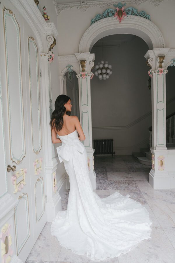 La Premiere Arabella Wedding Dress - A - Line style dress with sweetheart neckline, hand-placed floral appliqués, exposed boning bodice and long sleeves.